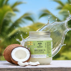 Jar of coconut oil with a coconut and splashing water against a natural background