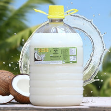 Coconut oil container with coconuts on a wooden surface, coconut trees in the background |Sarvaani Virgin Coconut Oil